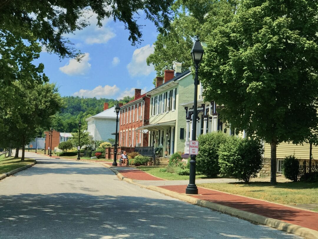 A row of well-kept houses stand on a tree-lined street.