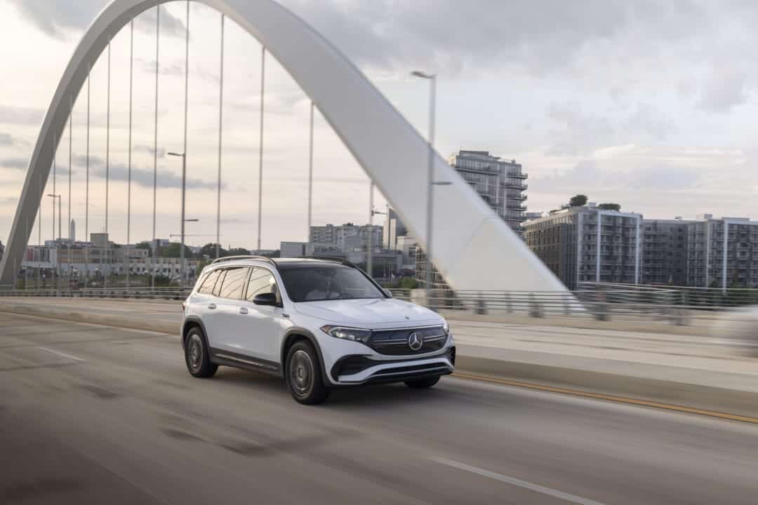 A white SUV drives across a scenic bridge.