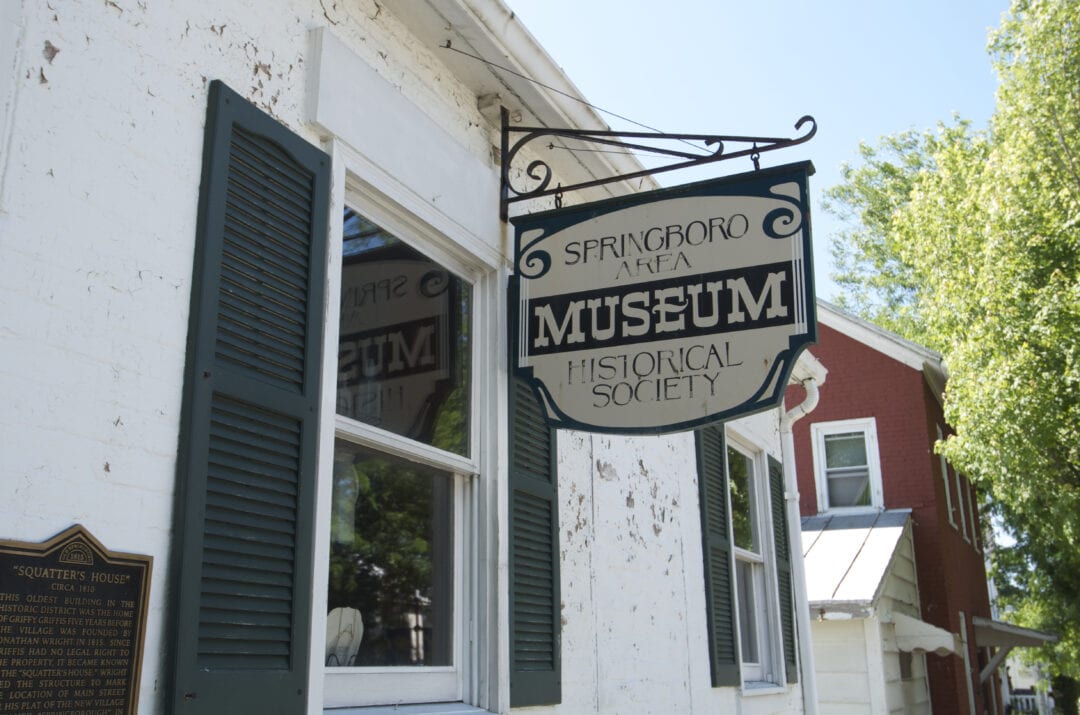 A well-worn metal sign marks the entrance to an unassuming museum.