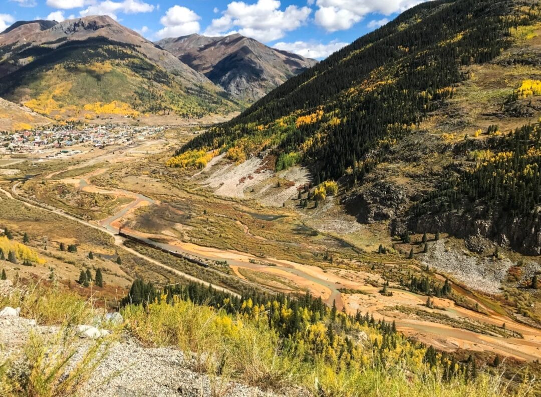 A rugged landscape is broken with mountains, scrub, and off-roading paths.