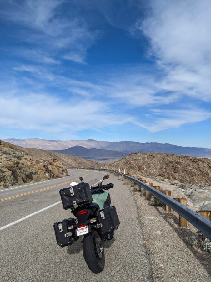 A motorcycle parked on the side of a curvy mountain road