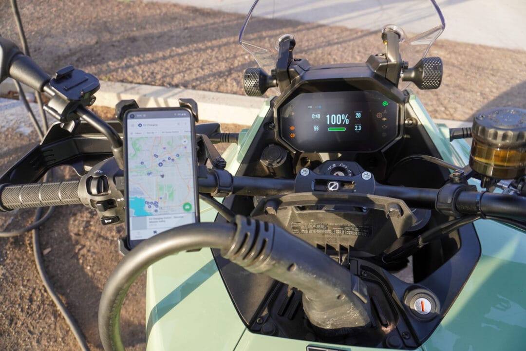 Closeup of an electric motorcycle plugged in to a charging station