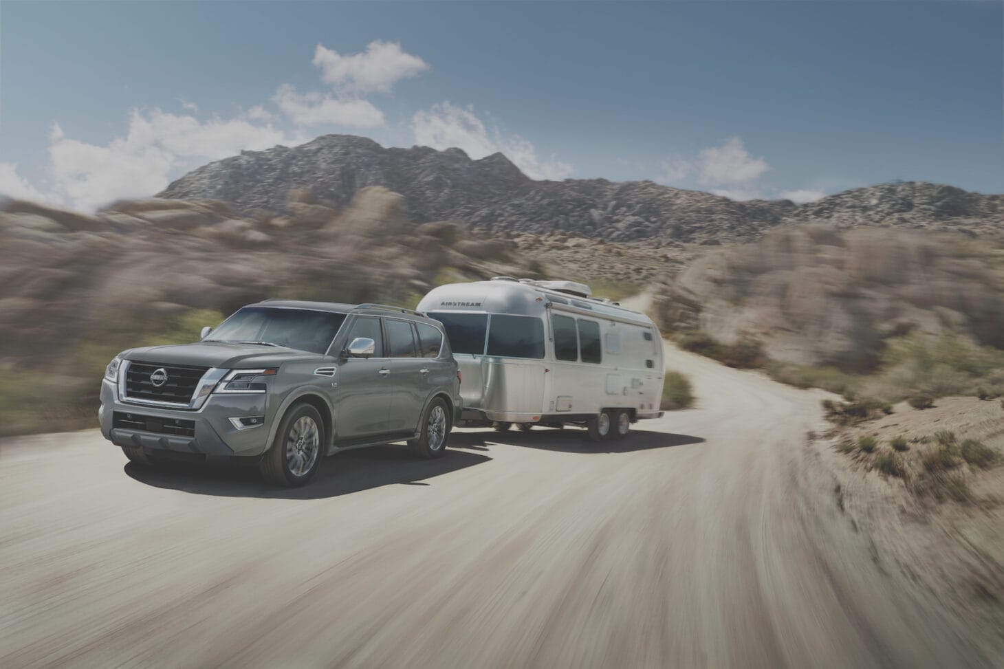 A Nissan Armada SUV towing a medium-sized trailer