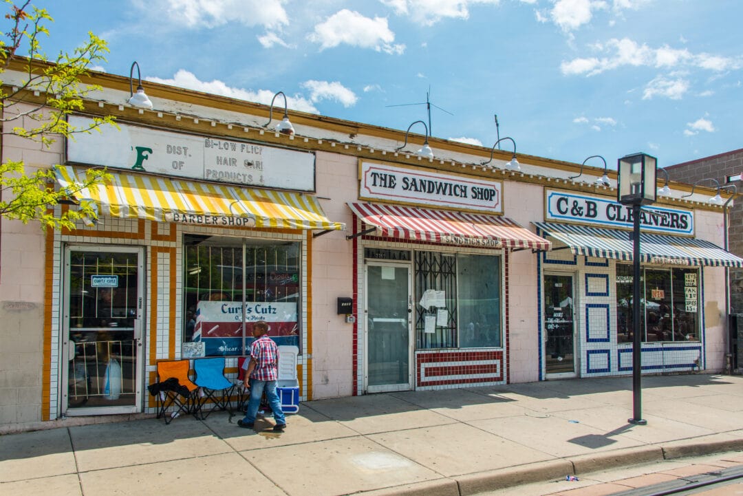 A street is lined with a row of shops that look as though they've been unchanged for decades.