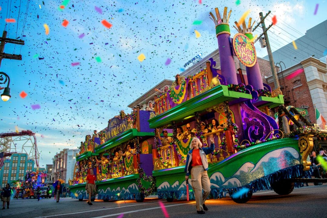 Colorful confetti fills the air as parade floats roll down a street at the Universal Studios Florida theme park.