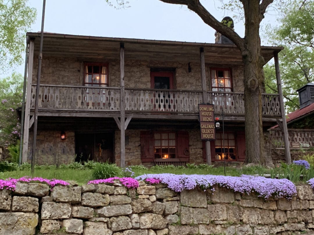 A wooden sign that reads "Galena's Oldest House" sits in front of a historic looking dwelling