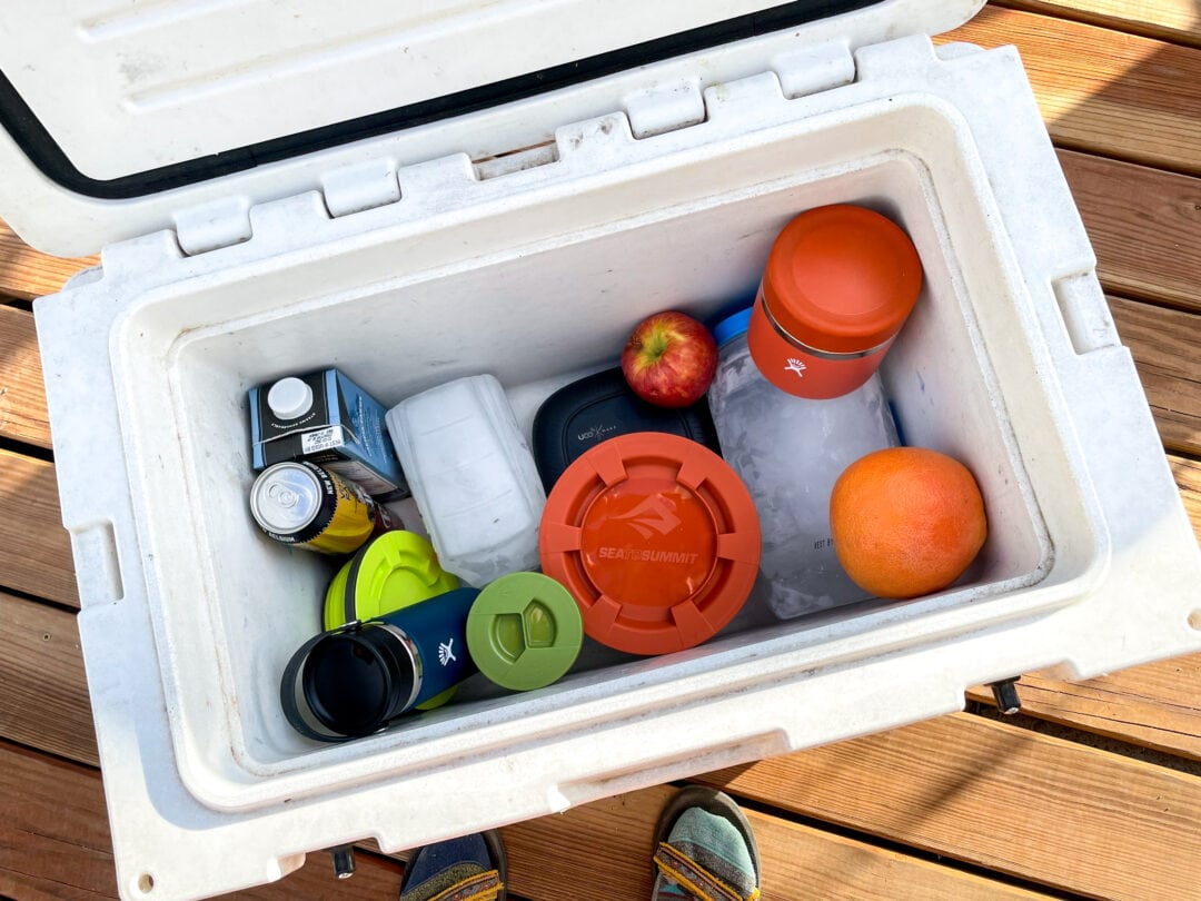 Assorted repurposed bottles are used as ice blocks in a cooler