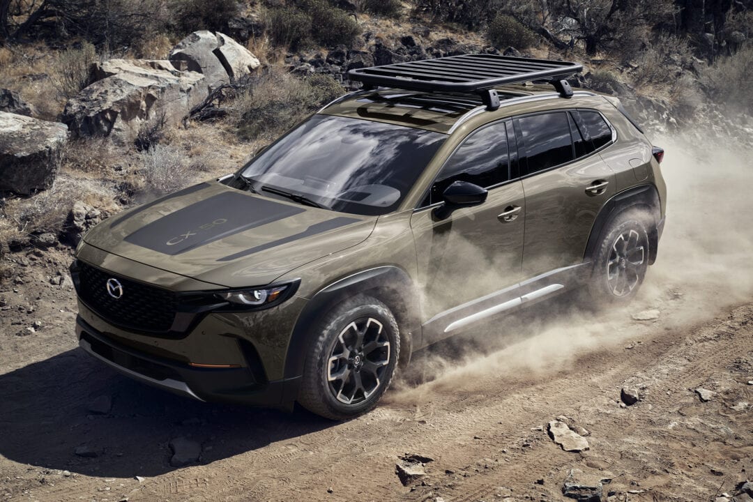A 2023 Mazda CX-50 Turbo Meridian Edition kicks up dirt as it drives through a dusty terrain